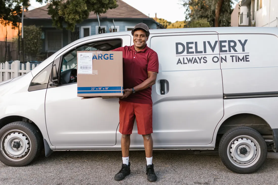 Smiling courier carrying packages for delivery